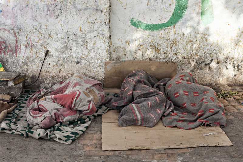 Schlafende Straßenkinder in Decken gehüllt