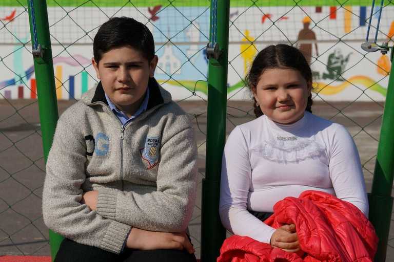 Ana und Mihail sitzen auf einer Bank vor dem Oratorium Don Boscos.