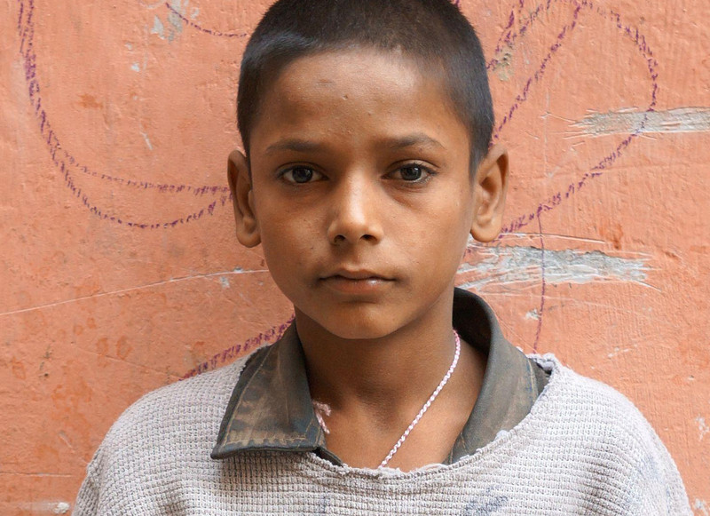 Junge in zerschlissener Kleidung