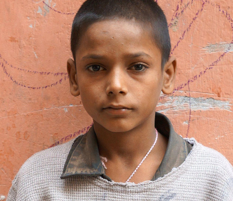 Junge in zerschlissener Kleidung