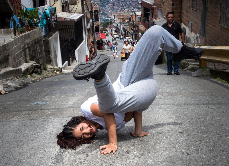 Mädchen macht Kopfstand auf einer Straße in Medellín