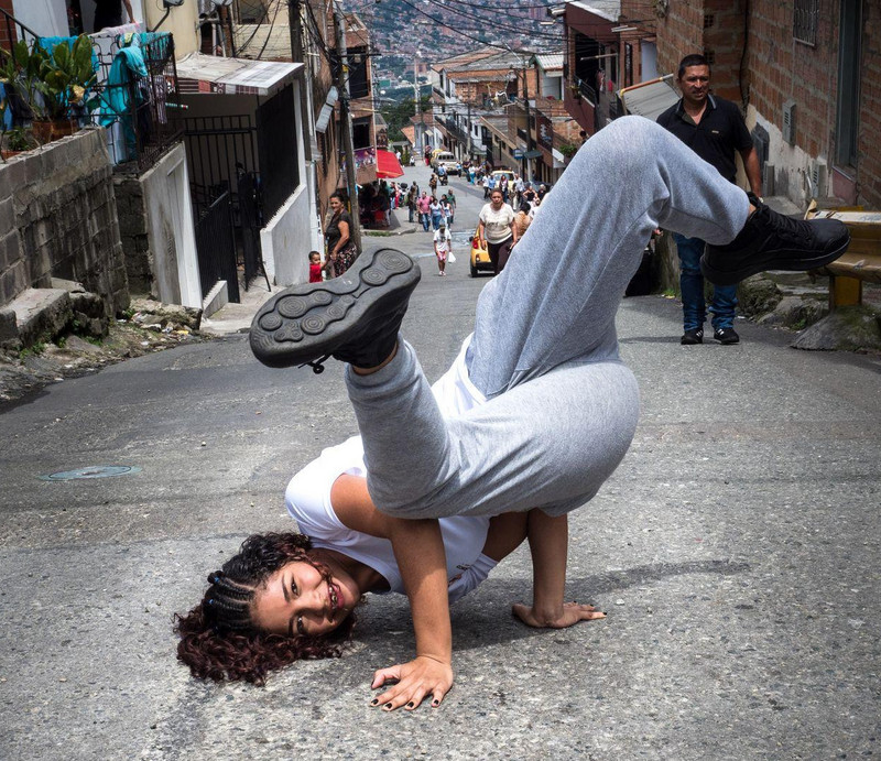 Mädchen macht Kopfstand auf einer Straße in Medellín