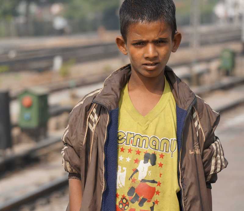 Junge steht an einem verlassenen Bahnsteig