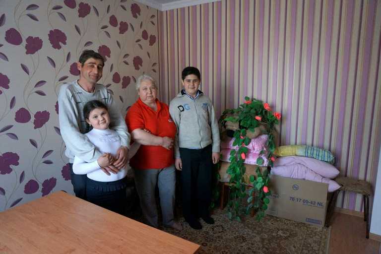 Ana, Mihail, Vater und Oma stehen im Wohnzimmer