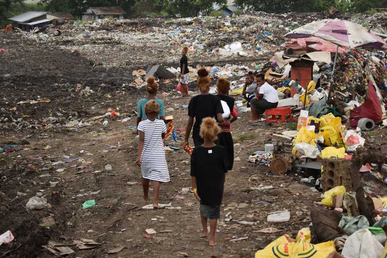 Frauen und Kinder laufen über die Müllberge