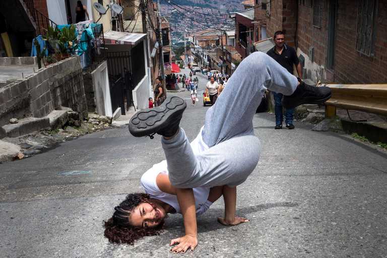 Mädchen macht Kopfstand auf einer Straße in Medellín